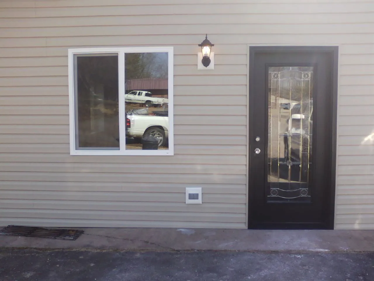 New siding, window and entry door on the side of an addition in New London
